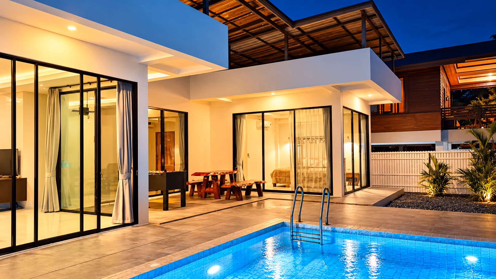 The Yang Yai villa at dusk: the lit plunge pool, covered terrace and tropical planting
